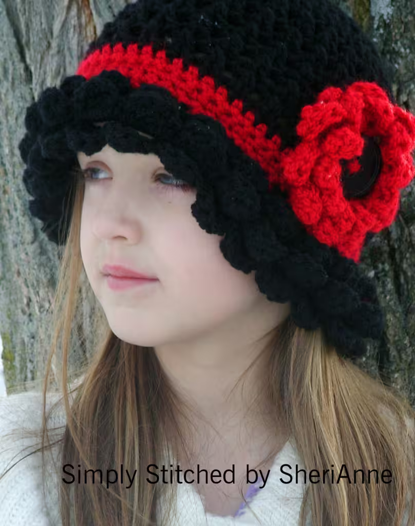Close-up of a black textured crochet Margarita Hat with a large red flower detail worn by a model